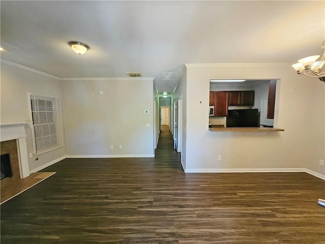 unfurnished living room featuring an inviting chandelier, crown molding, visible vents, and a premium fireplace