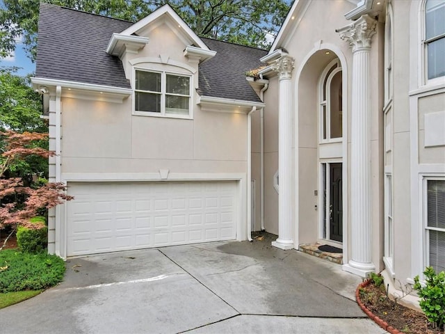 view of front of house featuring driveway, stucco siding, an attached garage, and roof with shingles