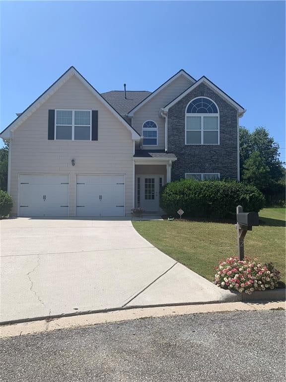 front facade featuring a garage and a front lawn