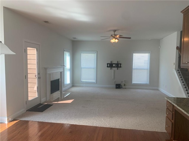 unfurnished living room with ceiling fan and light wood-type flooring