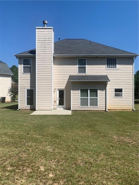 back of house featuring a patio area and a lawn