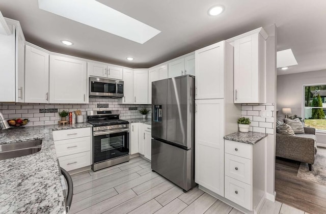 kitchen featuring a sink, a healthy amount of sunlight, tasteful backsplash, and stainless steel dishwasher