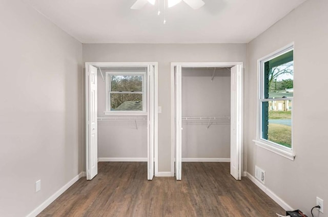 unfurnished bedroom featuring a ceiling fan, wood finished floors, visible vents, and baseboards