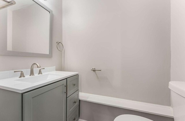 bathroom featuring tub / shower combination, vanity, and toilet