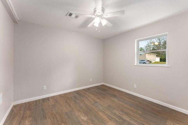 spare room with ceiling fan, wood finished floors, visible vents, and baseboards