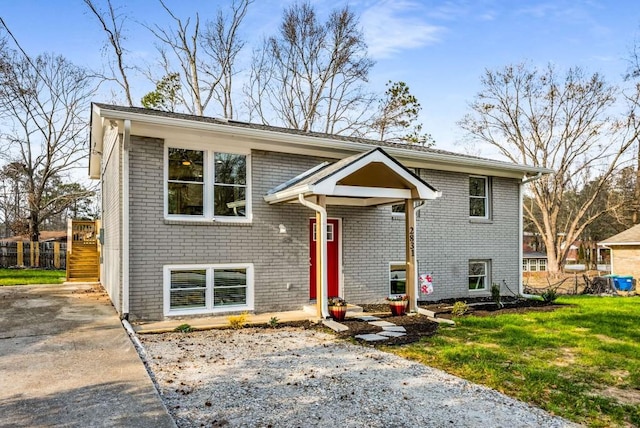 split foyer home featuring a front yard and brick siding