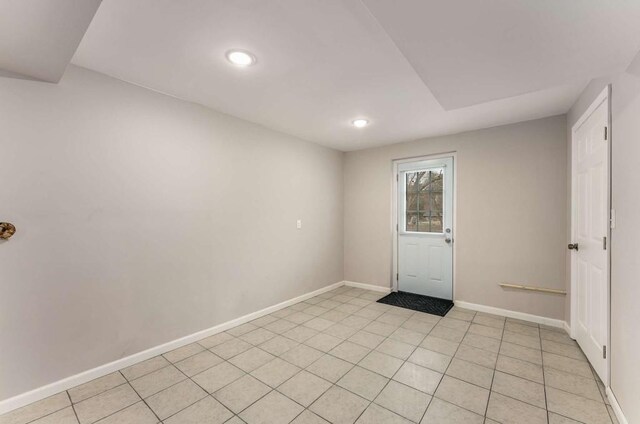 spare room featuring baseboards and light tile patterned floors