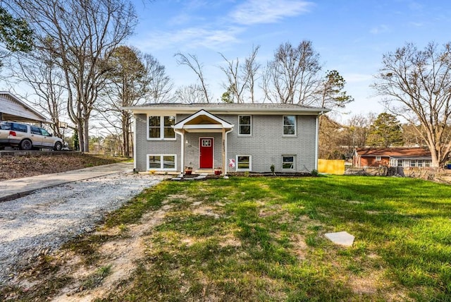 split foyer home featuring driveway, a front lawn, and brick siding