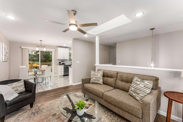 living area featuring baseboards, wood finished floors, a ceiling fan, and recessed lighting