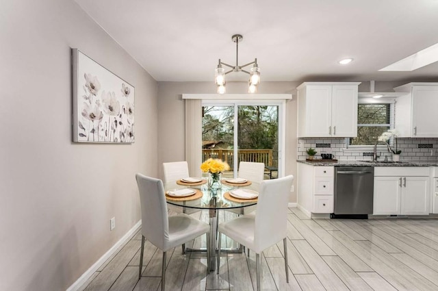 kitchen with tasteful backsplash, dark stone countertops, white cabinets, and stainless steel dishwasher