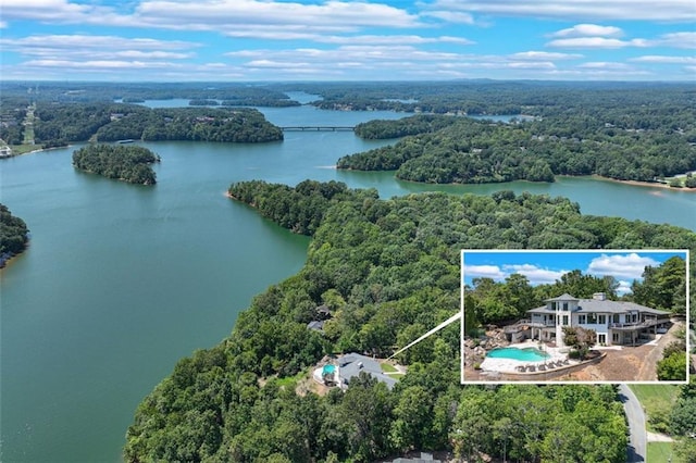 birds eye view of property featuring a wooded view and a water view