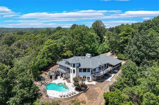 bird's eye view with a wooded view
