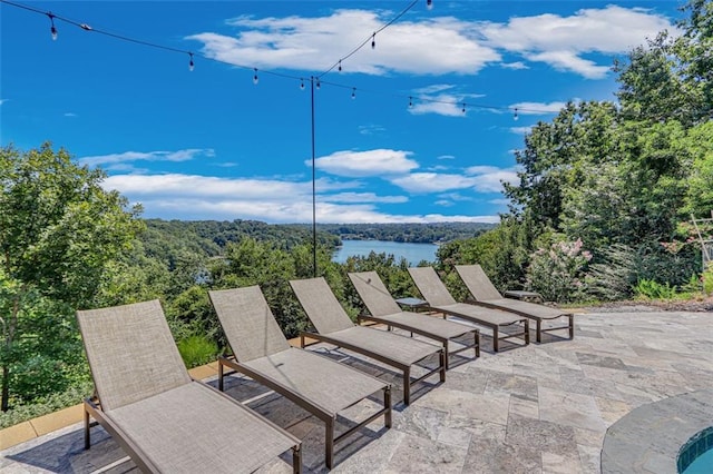 view of patio featuring a forest view and a water view