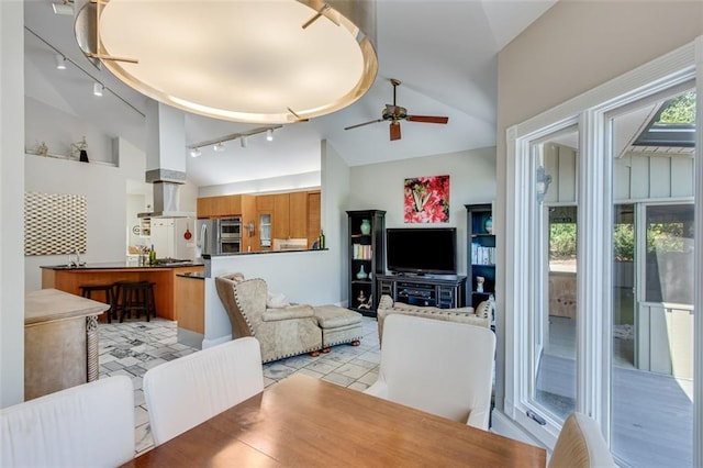 living room with ceiling fan, rail lighting, and high vaulted ceiling