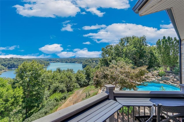 balcony featuring a view of trees and a water view