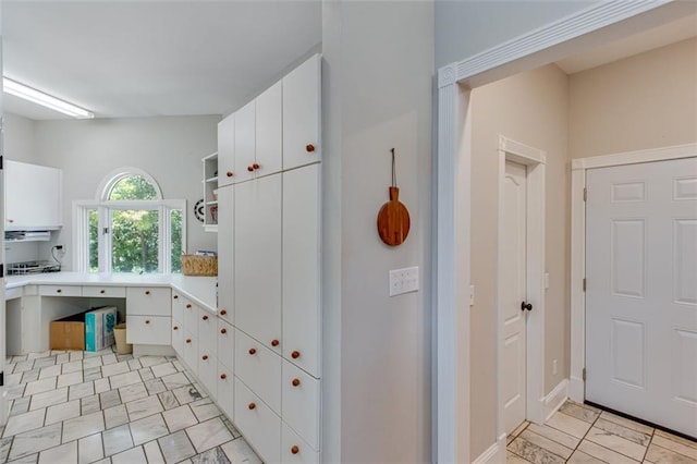 kitchen featuring white cabinets, light countertops, and open shelves