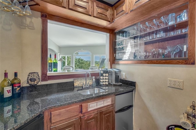 kitchen featuring sink, dishwasher, and dark stone countertops