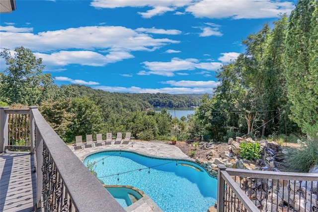 view of swimming pool with a hot tub and a water view