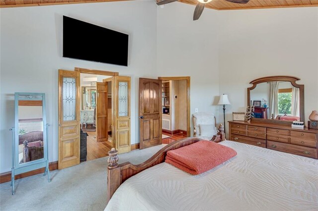 bedroom with high vaulted ceiling, ceiling fan, baseboards, and carpet flooring