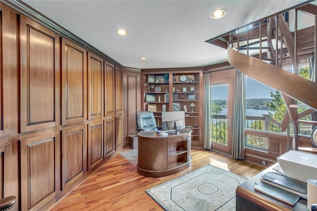 home office featuring light wood-style flooring, recessed lighting, and built in shelves