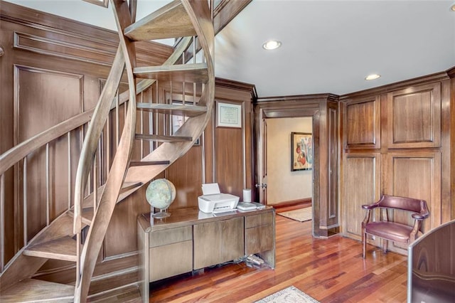 staircase featuring baseboards, wood finished floors, and recessed lighting