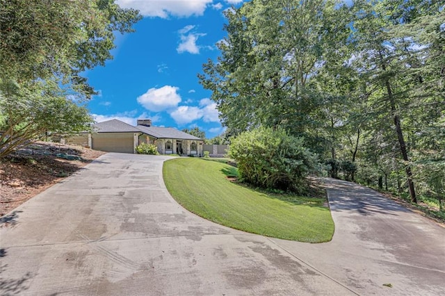 single story home with an attached garage, aphalt driveway, and a front yard