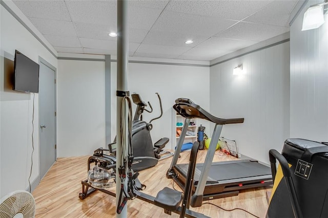 workout room with a drop ceiling and light hardwood / wood-style flooring