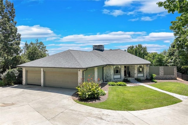 ranch-style home featuring an attached garage, stone siding, a front lawn, and concrete driveway
