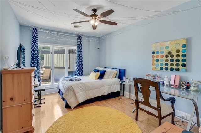 bedroom with baseboards, a ceiling fan, wood finished floors, and visible vents