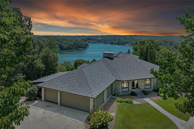 exterior space featuring a forest view and a water view