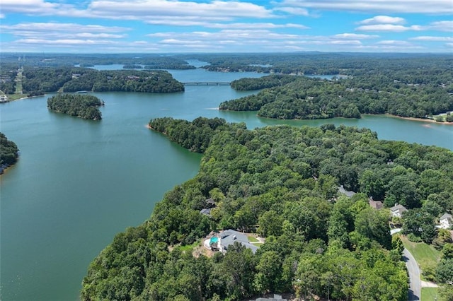 birds eye view of property featuring a forest view and a water view