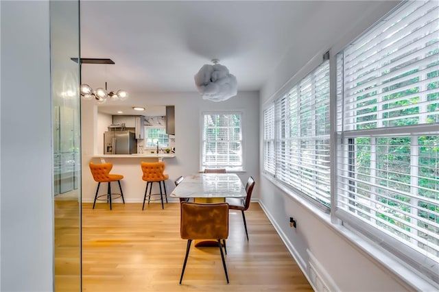 dining space featuring light hardwood / wood-style floors and a chandelier