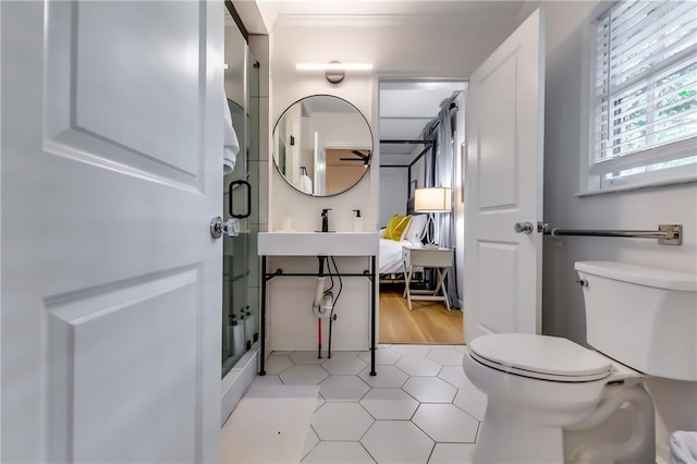 bathroom with a shower, tile patterned floors, toilet, and ornamental molding