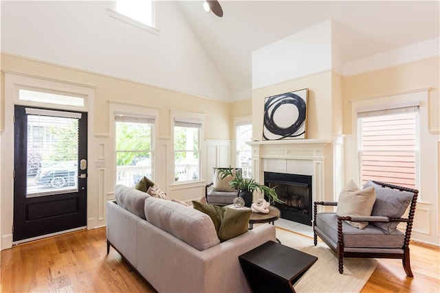 151 Savannah St SE, Atlanta, GA 30316 - living area featuring high vaulted ceiling, a decorative wall, a tile fireplace, light wood-type flooring, and a wainscoted wall