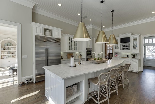 kitchen featuring dark wood-style floors, open shelves, stainless steel appliances, a spacious island, and white cabinetry