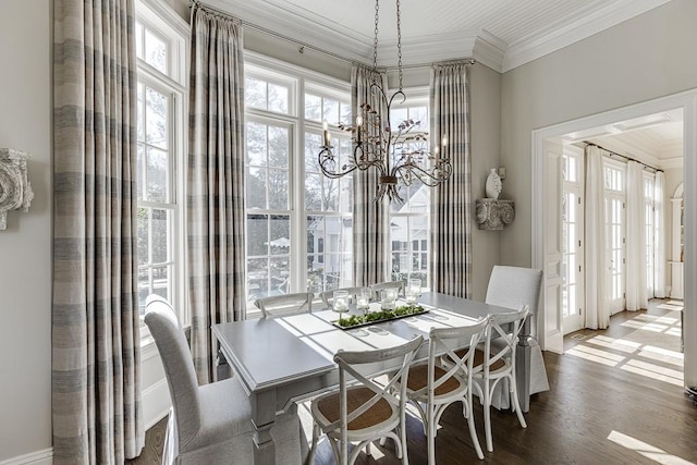 dining space featuring crown molding, wood finished floors, and an inviting chandelier