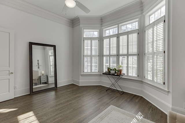 unfurnished room with baseboards, wood finished floors, a ceiling fan, and crown molding