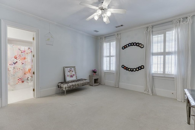 sitting room with a wealth of natural light, carpet floors, ornamental molding, and visible vents