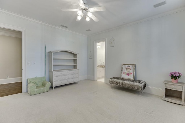 sitting room with carpet, visible vents, and crown molding