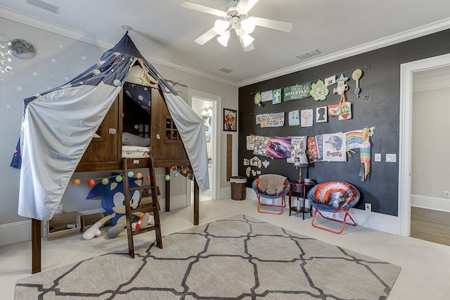 playroom with ceiling fan, carpet floors, visible vents, baseboards, and crown molding