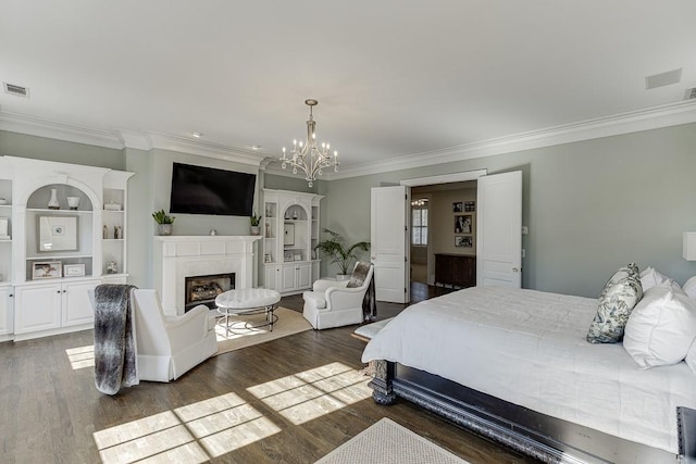 bedroom with dark wood-style floors, a premium fireplace, a chandelier, and crown molding