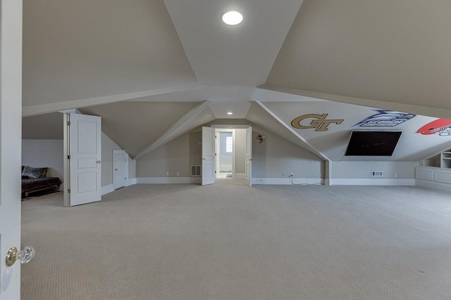 additional living space with lofted ceiling, baseboards, visible vents, and light colored carpet