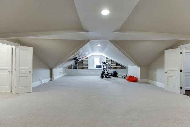 additional living space with carpet floors, lofted ceiling, and baseboards