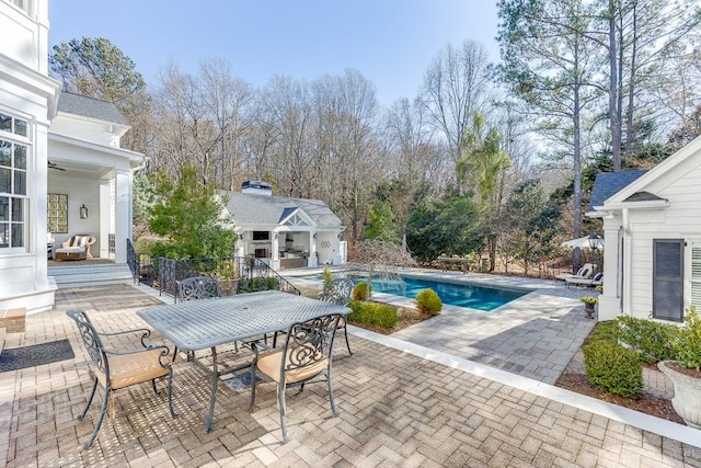 view of pool featuring a fenced in pool, outdoor dining area, a patio area, an outdoor structure, and a storage structure