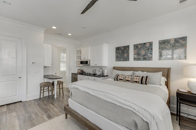 bedroom with baseboards, visible vents, ornamental molding, wood finished floors, and recessed lighting