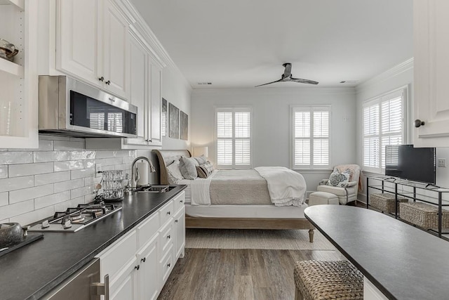 bedroom with a sink, dark wood-style floors, multiple windows, and crown molding