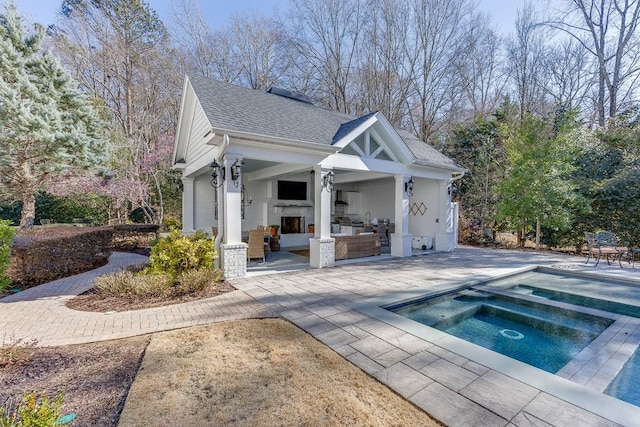 view of pool with a storage structure, a patio area, an in ground hot tub, and an outdoor structure