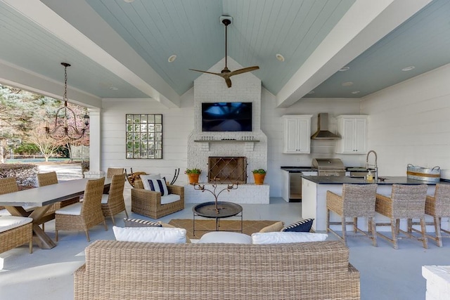 living room with concrete flooring, ceiling fan with notable chandelier, vaulted ceiling, and an outdoor brick fireplace