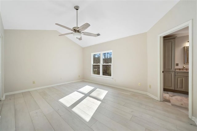 unfurnished bedroom featuring light hardwood / wood-style floors, sink, ceiling fan, connected bathroom, and lofted ceiling