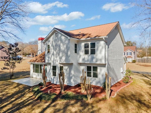 back of property with a patio area and a lawn